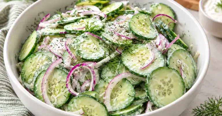 Romige komkommersalade met knoflook en dille in een witte schaal